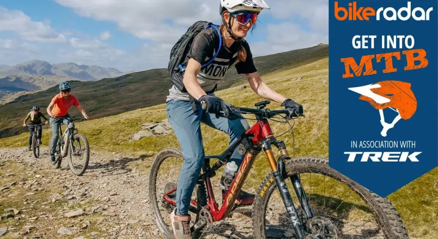Three friends enjoy a sunny day of cross country biking on a rocky mountain trail, with a "Get Into MTB" logo in the corner.