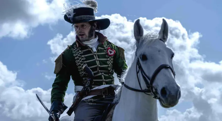 Un officier à cheval, sabre à la main, dans son uniforme vert et son chapeau à panache, incarne le dernier panache histoire.