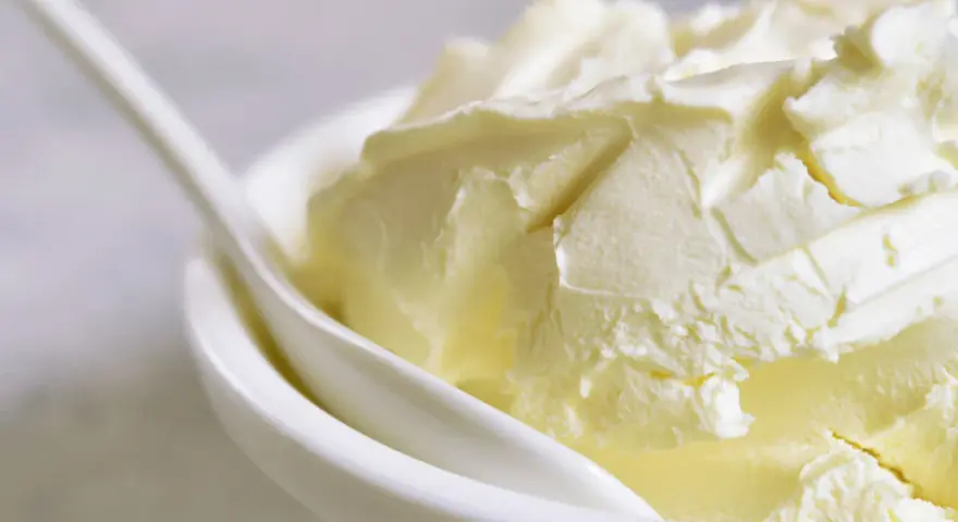 Kremowa masa w białej miseczce, idealna jako zamiennik mascarpone do deserów.