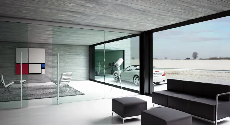 Interior moderno con sofá negro, sillones y una gran pared de cristal que da a un paisaje nevado y un coche descapotable.