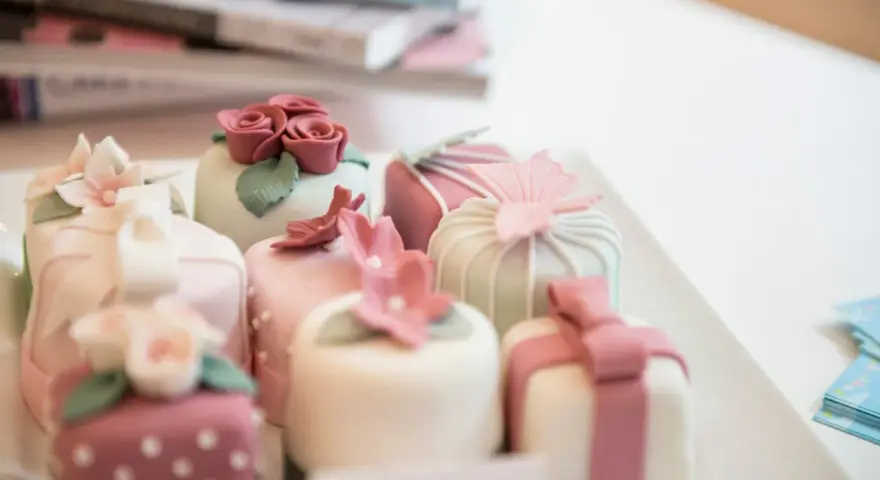 Urocze mini deserki, idealne na tort panieński. Różowe różyczki, kwiaty i kokardki zdobią słodkości.