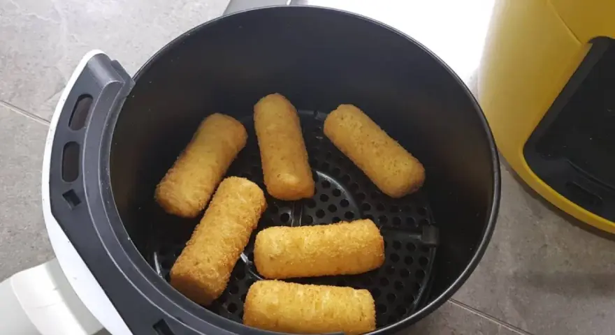 Crocchette di patate dorate e croccanti pronte per essere gustate, appena uscite dalla friggitrice ad aria.