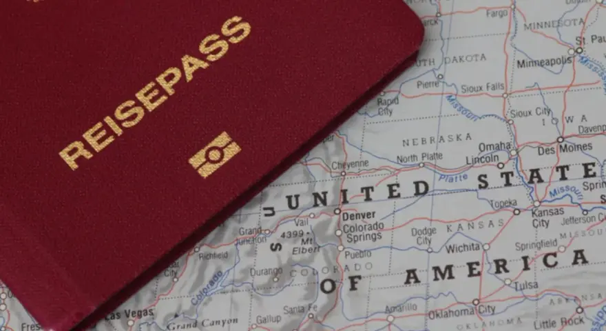 Ein roter Reisepass liegt auf einer Karte der USA. Perfekt für deinen **Gap Year USA** Traum!