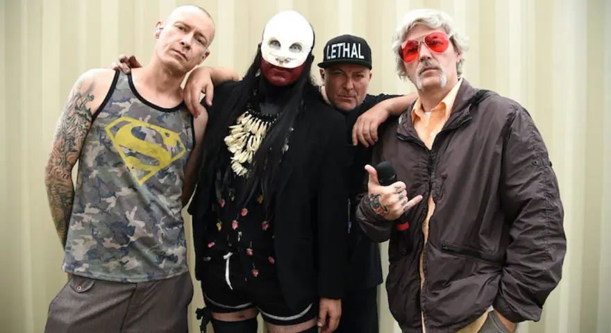 Członkowie Limp Bizkit, gotowi by break stuff, pozują do zdjęcia. Jeden w koszulce z Supermanem, drugi w masce, trzeci w czapce "Lethal", a czwarty z mikrofonem.