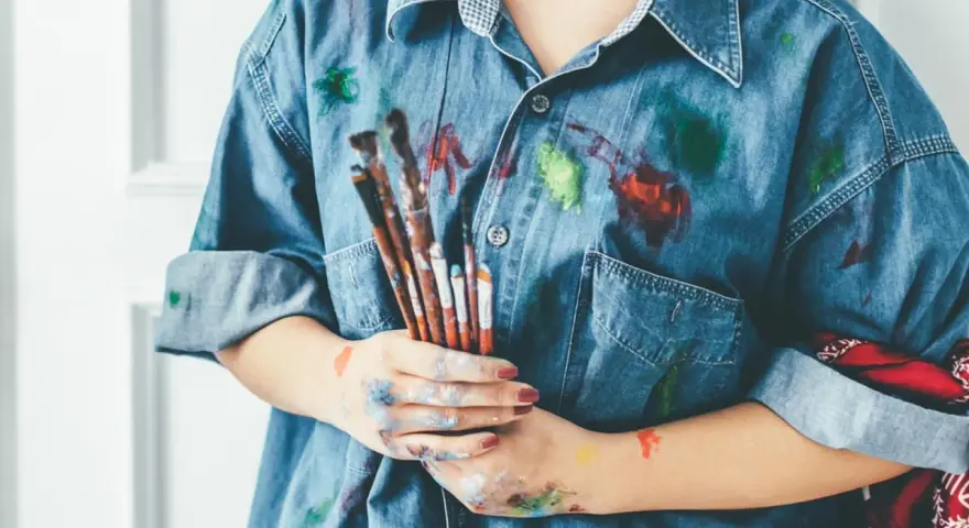 Manos manchadas de tempera y una camisa vaquera salpicada de pintura. ¡Un desafío para quitar tempera de la ropa!