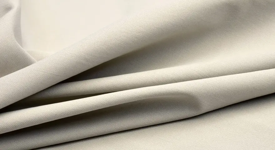 Beżowy, elastyczny materiał, który świetnie sprawdzi się w odzieży sportowej. Spandex co to? To właśnie ten materiał!