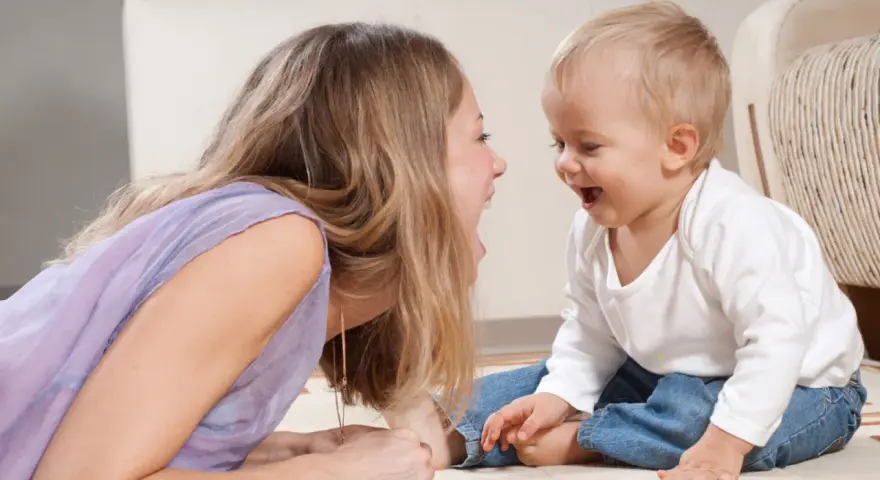 Frau und Baby lachen sich an. Sie unterhalten sich, zahlen ohne Sorgerecht, aber die Freude ist echt.