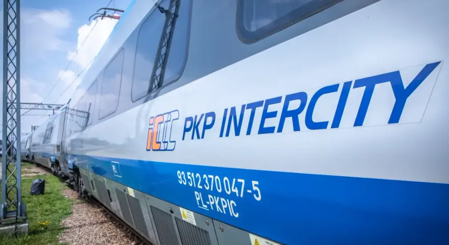Pociąg PKP Intercity z niebieskim pasem i logo.