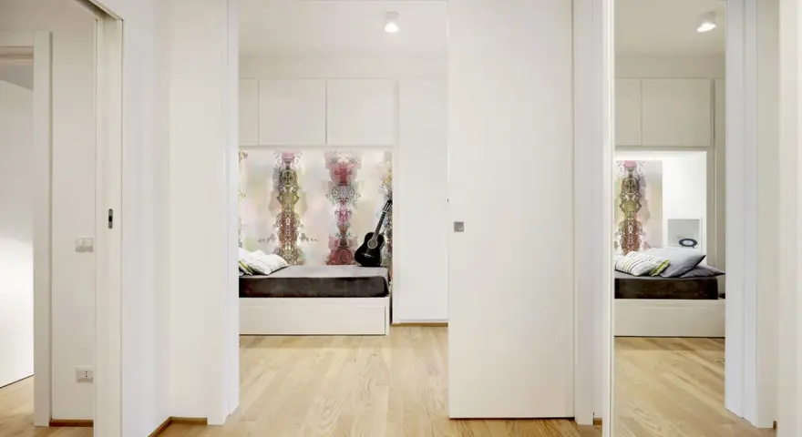 Un letto a scomparsa e una porta scorrevole creano una stanza in più, trasformando un corridoio in uno spazio accogliente.