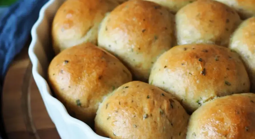 Frisch gebackene, goldbraune Brötchen mit Kräutern, bereit zum Genießen. Ein perfektes kleines Brot backen für jeden Anlass.