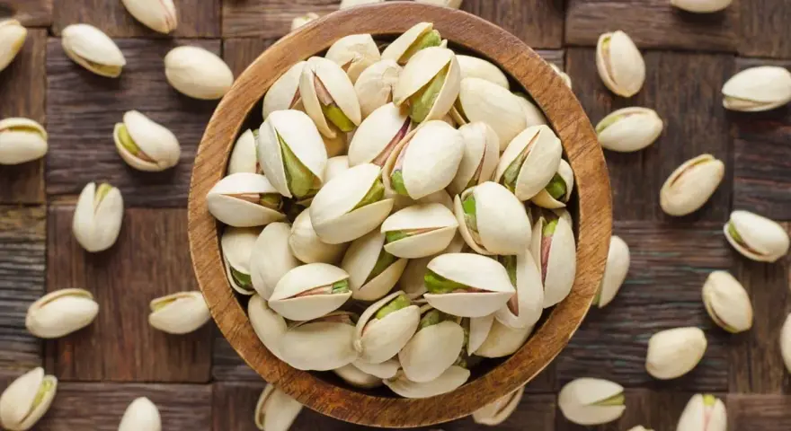 Miseczka pełna pistacji, które są świetną przekąską. Warto sprawdzić ich pistacje kcal przed spożyciem.