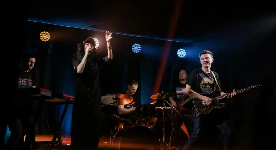 Zespół rockowy na scenie: wokalistka, gitarzysta, basista, perkusista i klawiszowiec. Koncert jak z listy zespoły rockowe zagraniczne alfabetycznie.