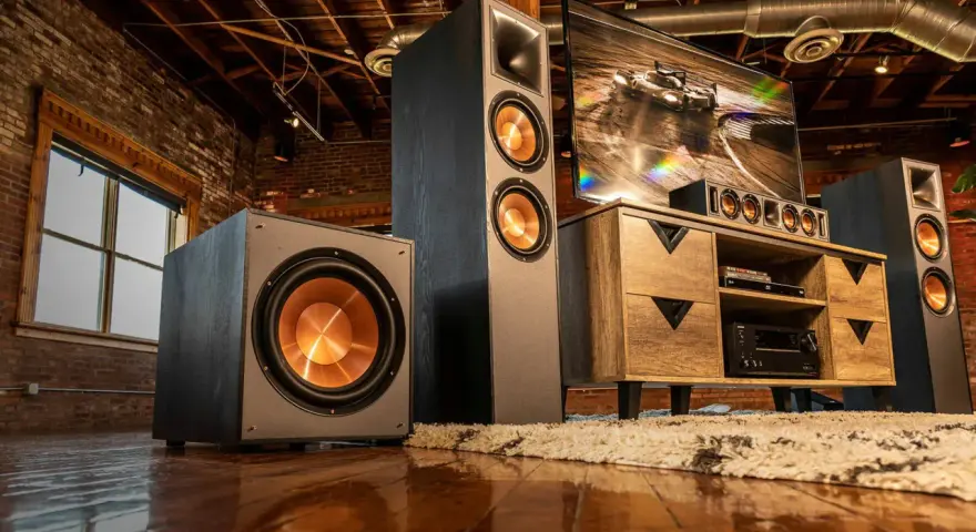 Idealne ustawienie subwoofera i głośników w industrialnym salonie. Ciemne kolumny i subwoofer z miedzianymi membranami tworzą stylowy zestaw audio.