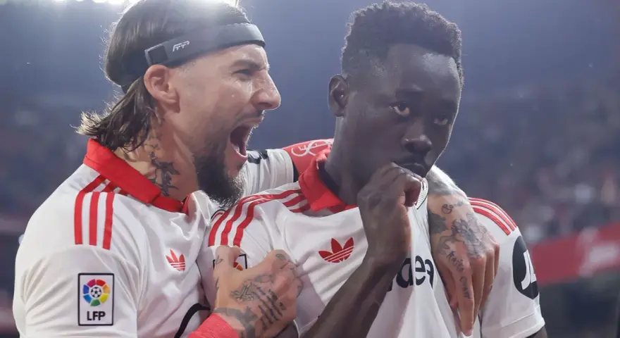 Jugadores del Sevilla FC celebran un gol contra el Atlético de Madrid. Uno grita con euforia, el otro reflexiona.