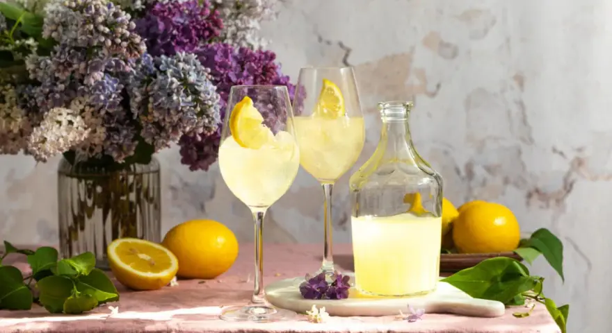 Erfrischender Limoncello mit frischen Zitronen, Eis und einem Hauch von Flieder. Die perfekten Zutaten für einen Sommerabend.