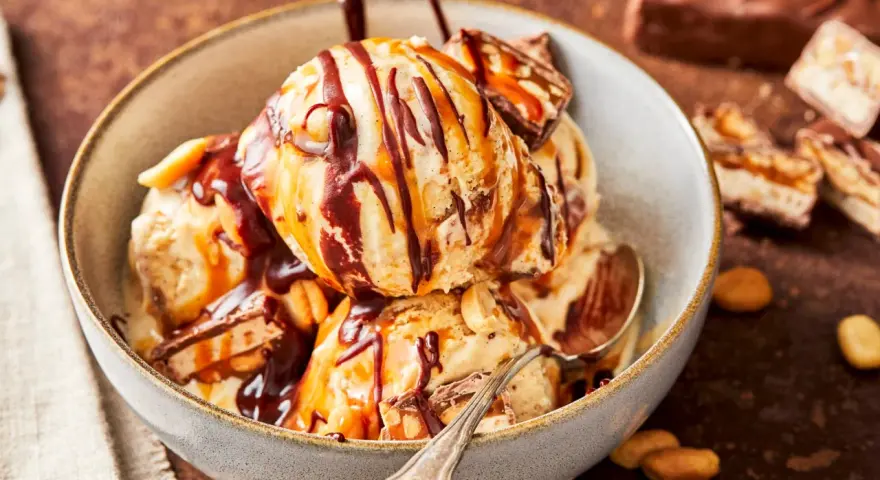 Schokoladiges Eis mit Karamell und Erdnüssen, perfekt für alle, die Snickers Eis selber machen wollen.