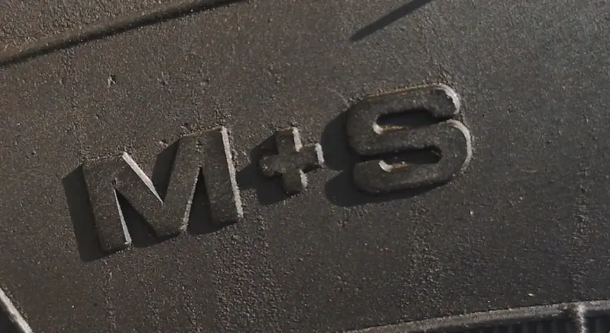 Napis "M+S" na bieżniku opony, oznaczający gotowość na błoto i śnieg.
