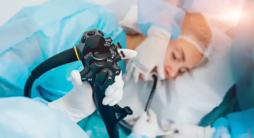 Gastroskopia ze znieczuleniem w toku. Lekarz trzyma endoskop, przygotowując się do badania pacjenta.