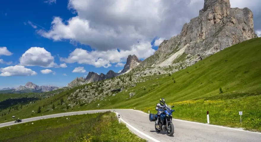 Motociclista su strada panoramica tra le montagne, un invito a scoprire le **strade da fare in moto** con panorami mozzafiato.