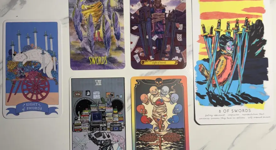 Cinco cartas del tarot, la mayoría con espadas, sobre un fondo blanco.