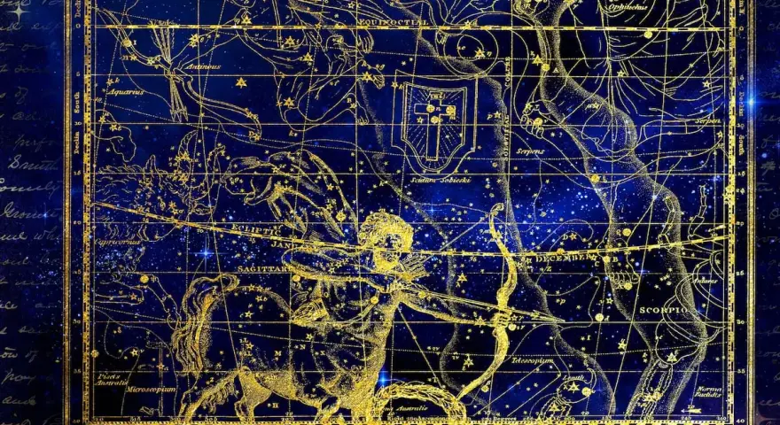 Mapa estelar dorado sobre fondo azul. Representa constelaciones y la eclíptica, clave para entender qué es el ascendente en la carta astral.