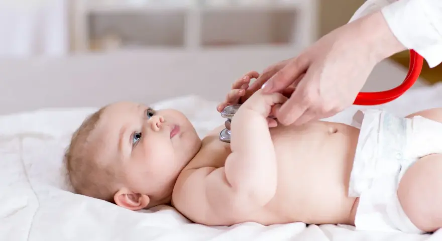 Lekarz osłuchuje niemowlę stetoskopem. Badanie może pomóc w wykryciu chorób metabolicznych u dzieci, lista schorzeń jest długa.