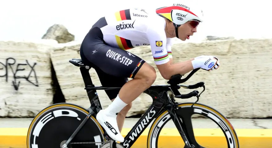 Cyclist in full aerodynamic gear, focused on time trial training, pushing hard on a specialized bike.