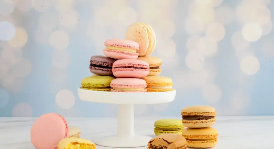 Bunte Macarons auf einem weißen Tortenständer, ein leckeres Macarons rezept zum Nachmachen.