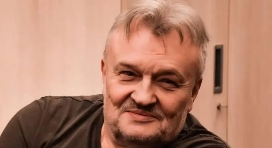 Uśmiechnięty Krzysztof Cugowski, z siwiejącymi włosami i zarostem. Zastanawiasz się, ile lat ma Krzysztof Cugowski?