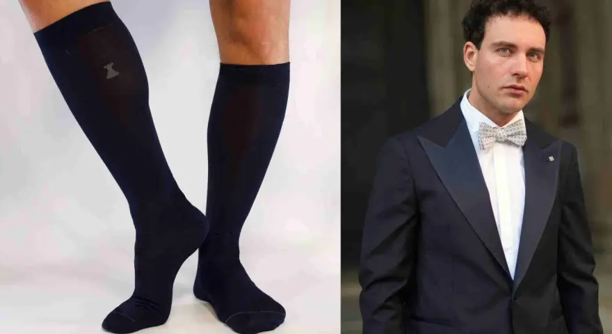 Un uomo elegante con smoking e papillon abbinato a calzini scuri.