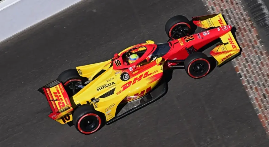 Alex Palou, piloto del coche número 10, acelera en la pista con su monoplaza amarillo y rojo de DHL.