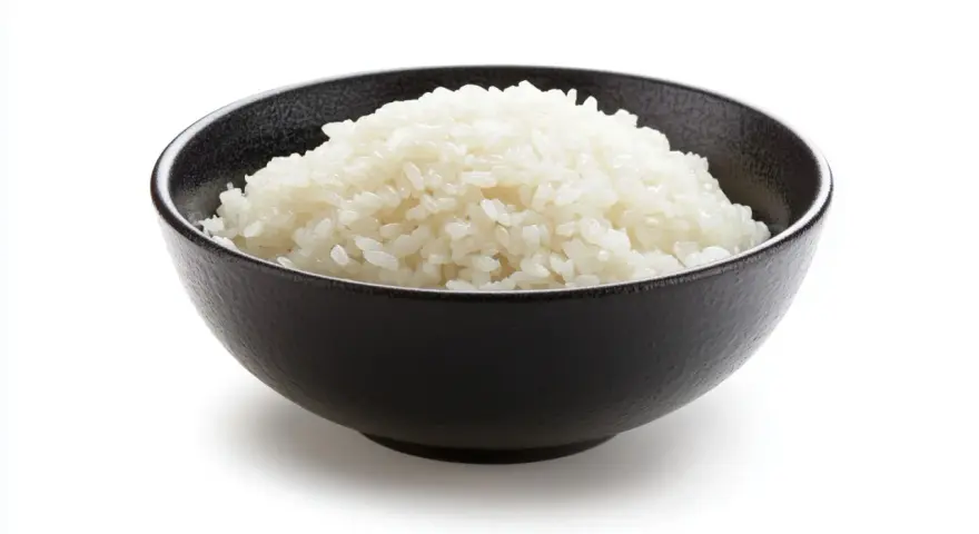 Un tazón negro lleno de arroz blanco esponjoso, listo para ser parte de un delicioso arroz frito.