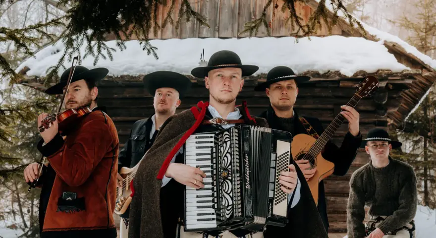 Zespół weselny gra na skrzypcach, akordeonie, gitarze i basach. Muzycy w tradycyjnych strojach góralskich.