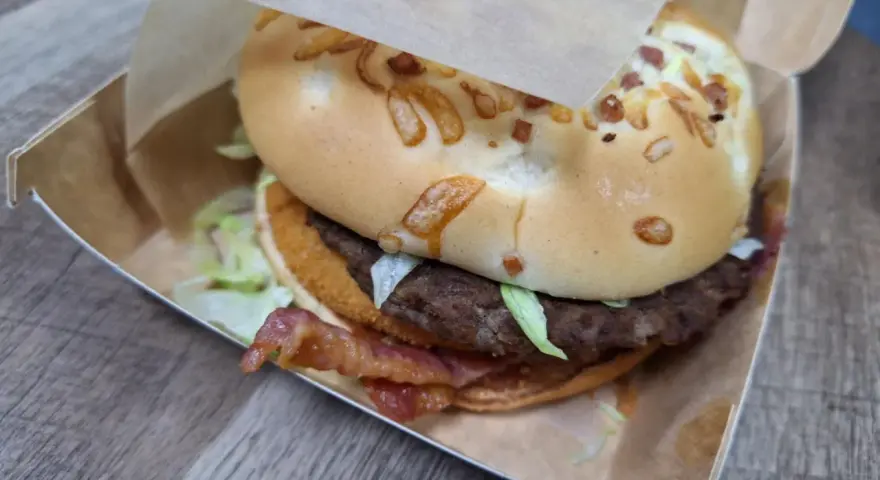 Burger domowy kontra cheeseburger z sieciówki. Ten domowy burger z bekonem i serem na bułce wygląda apetycznie.