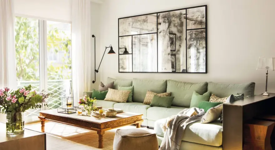 Un espejo grande y decorativo es una excelente idea de qué poner detrás del sofá, aportando amplitud y estilo a la sala.