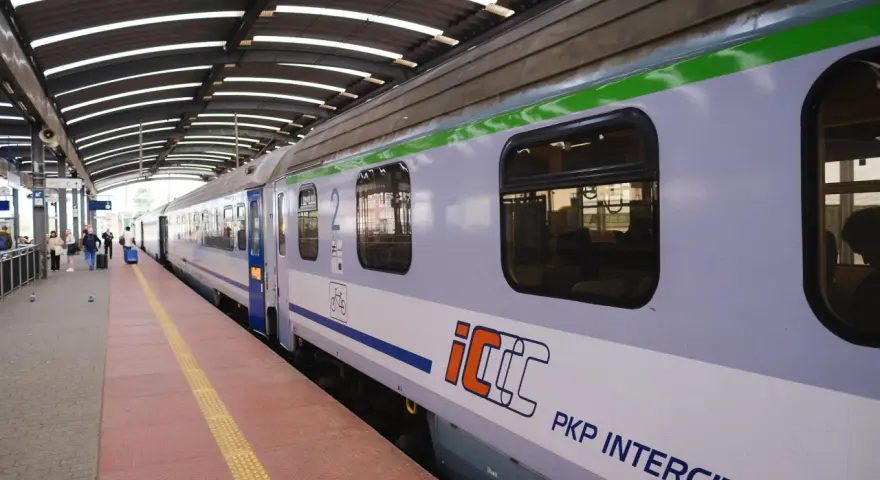 Pociąg PKP Intercity na peronie, z widocznymi oknami i logo.