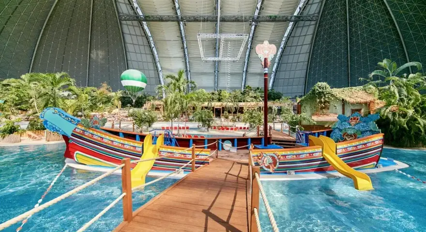 Kolorowy statek z żółtymi zjeżdżalniami w tropikalnym basenie. Idealne miejsce na wakacje, sprawdź bilety na tropical islands!