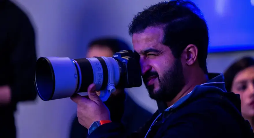 Un fotografo con una Canon EOS scatta foto, pensando a quanto guadagna un fotografo.