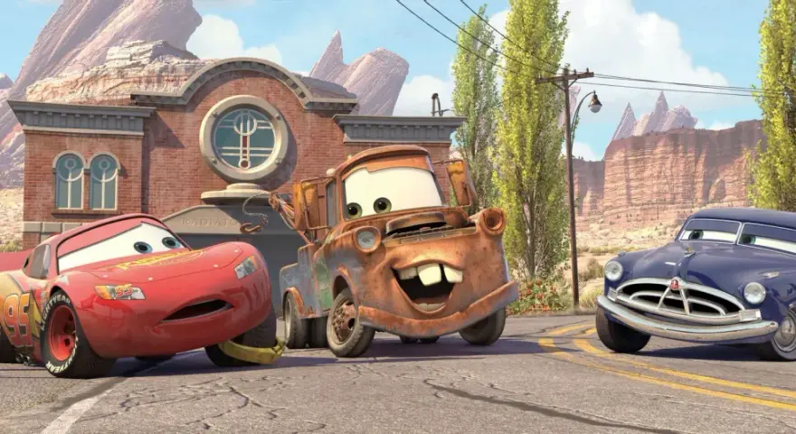 Zabawne auta z bajki: Zygzak McQueen, Złomek i Doc Hudson na tle Route 66.