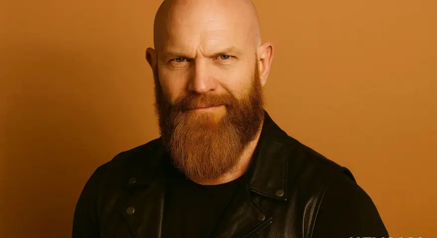 Hombre calvo con barba vikinga, mirada intensa y chaqueta de cuero.