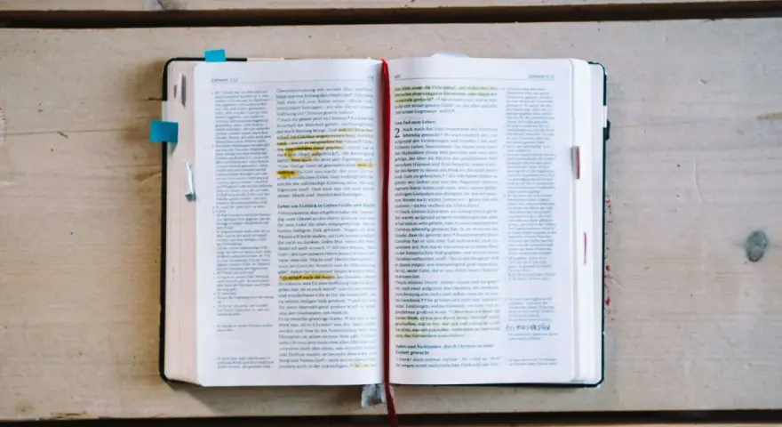 Ein aufgeschlagenes Buch mit Bibeltexten, das die Frage "was bedeutet evangelisch" beleuchtet.