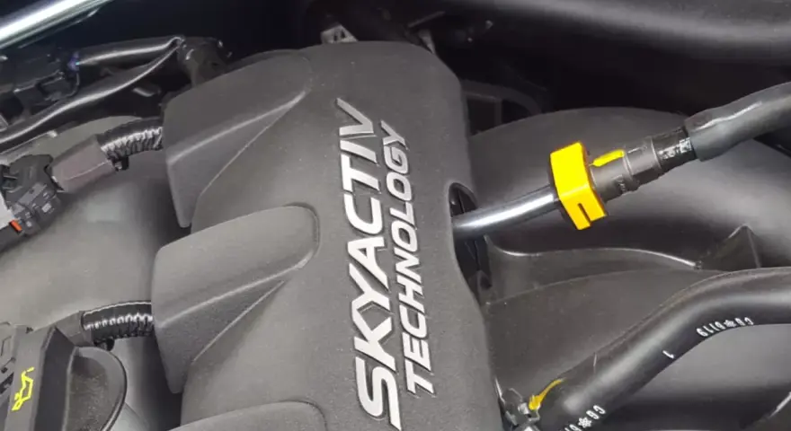 Silnik SKYACTIV TECHNOLOGY, prawdopodobnie najlepszy silnik benzynowy, z widocznymi przewodami i złączkami.