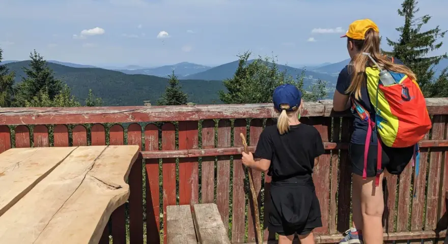 Dwie dziewczynki podziwiają malownicze widoki z tarasu. To idealne miejsce na odkrywanie widokowych szlaków blisko Krakowa.