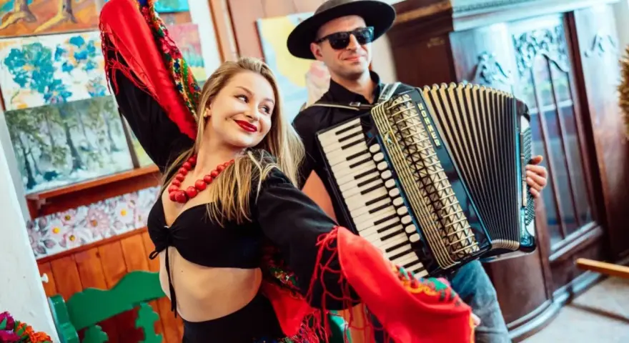 Zespół góralski disco polo w akcji! Wokalistka w barwnym stroju i akordeonista tworzą radosną atmosferę.