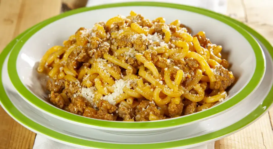 Piatto di gramigna alla salsiccia, condita con ragù saporito e una spolverata di parmigiano.