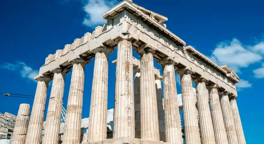 Le Parthénon, temple d'Athéna, se dresse majestueusement sous un ciel bleu éclatant, ses colonnes doriques témoignant de la grandeur de l'Acropole d'Athènes.