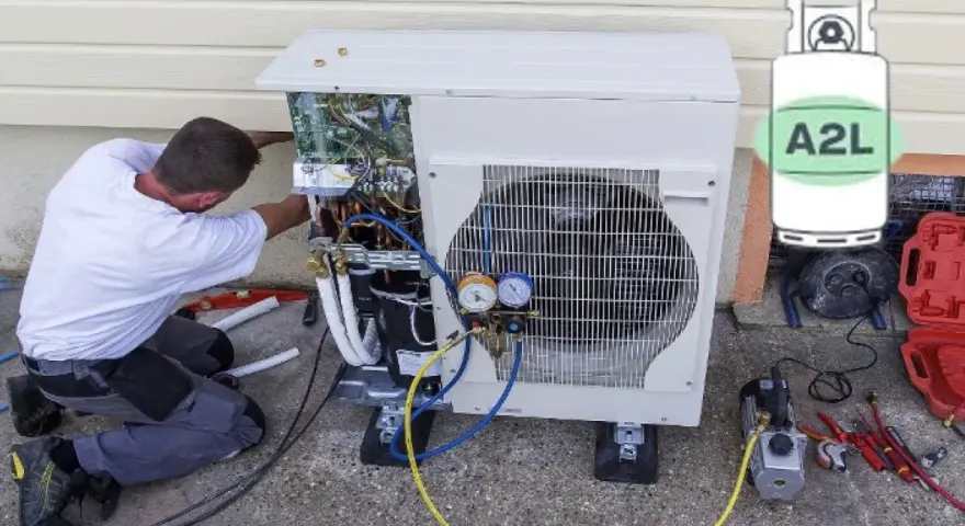Técnico trabajando en unidad exterior de aire acondicionado, con manómetros y cilindro de refrigerante A2L.