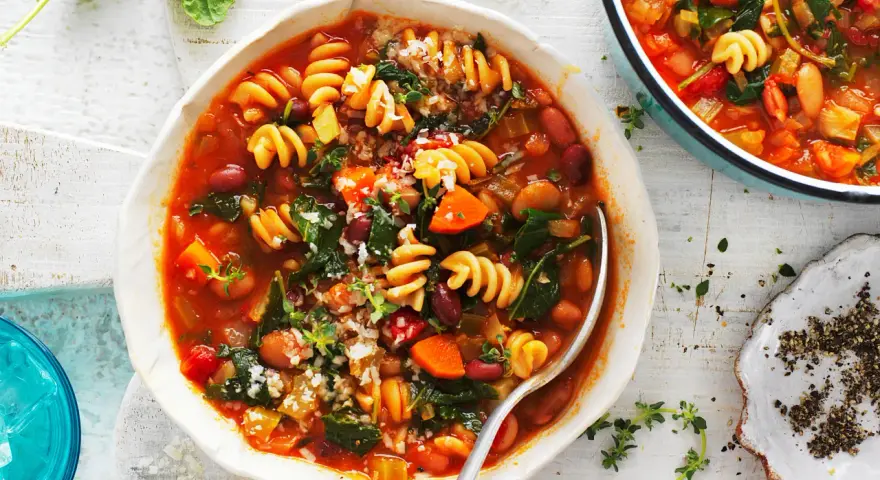 Aksamitna zupa minestrone z makaronem, fasolą i warzywami, posypana parmezanem. Idealna na chłodne dni.