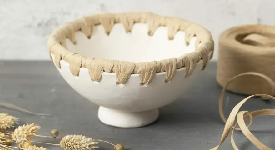 En skål av lufttorkande lera med en flätad kant av naturmaterial. Perfekt för dina egna lufttorkande lera ideer.