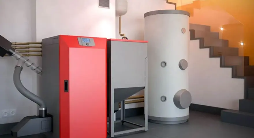 Instalación moderna para cambiar caldera de gas por pellets. Caldera roja, depósito de pellets y acumulador de agua.
